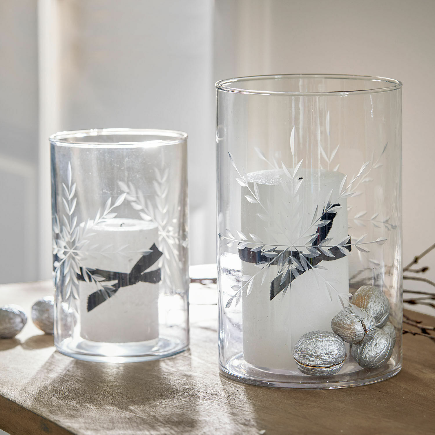 Windlicht set van 2 Snowflakes Glazen windlichten met witte kaarsen en zilveren noten op houten tafel, feestelijke decoratie