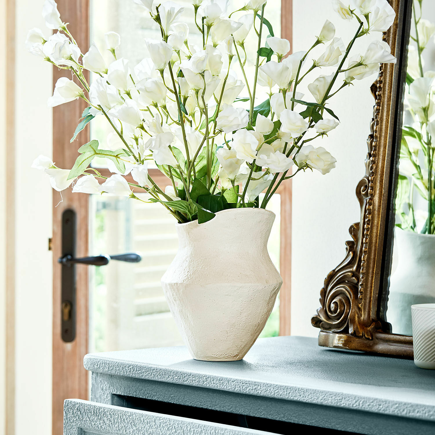 Vaas Cantresse Witte keramische vaas met textuur op kast met decoratieve bloemen in lichte kamer