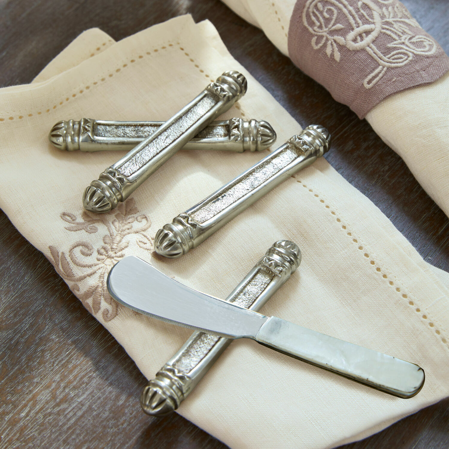 Messenbankje set van 4 Lafox Zilverkleurige metalen messenhouders op crèmekleurige geborduurde servet, elegant tafelset