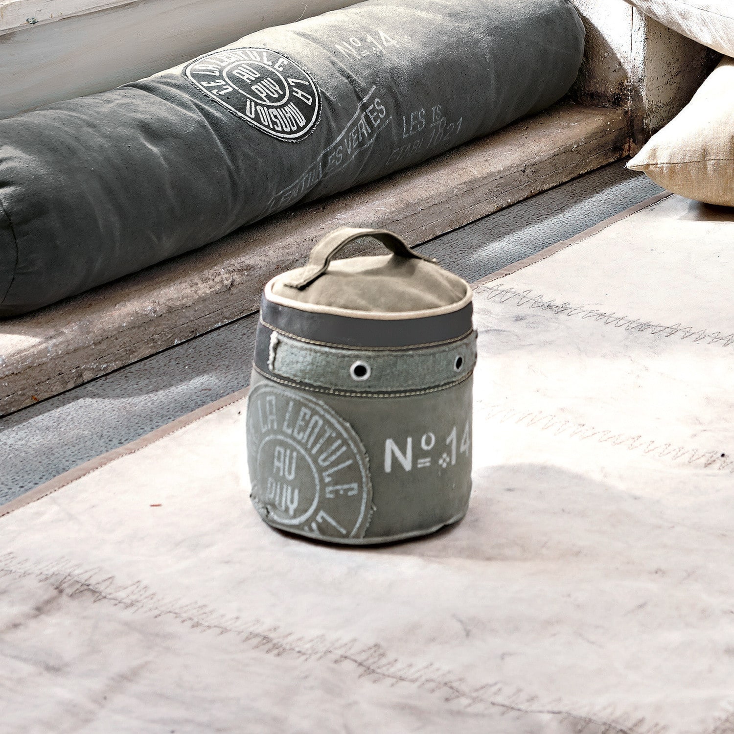 Deurstopper au Puy Grijze stoffen container met handvat en vintage print op lichte vloerkleed in loftstijl