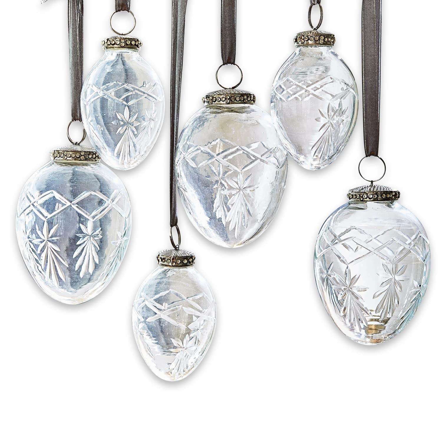 Transparante glazen kerstversieringen met gegraveerd patroon en bruine lint om op te hangen