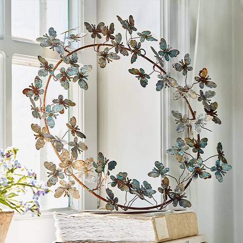 Decoratieve metalen krans met blauwe en bruine vlinders, stijlvolle woondecoratie