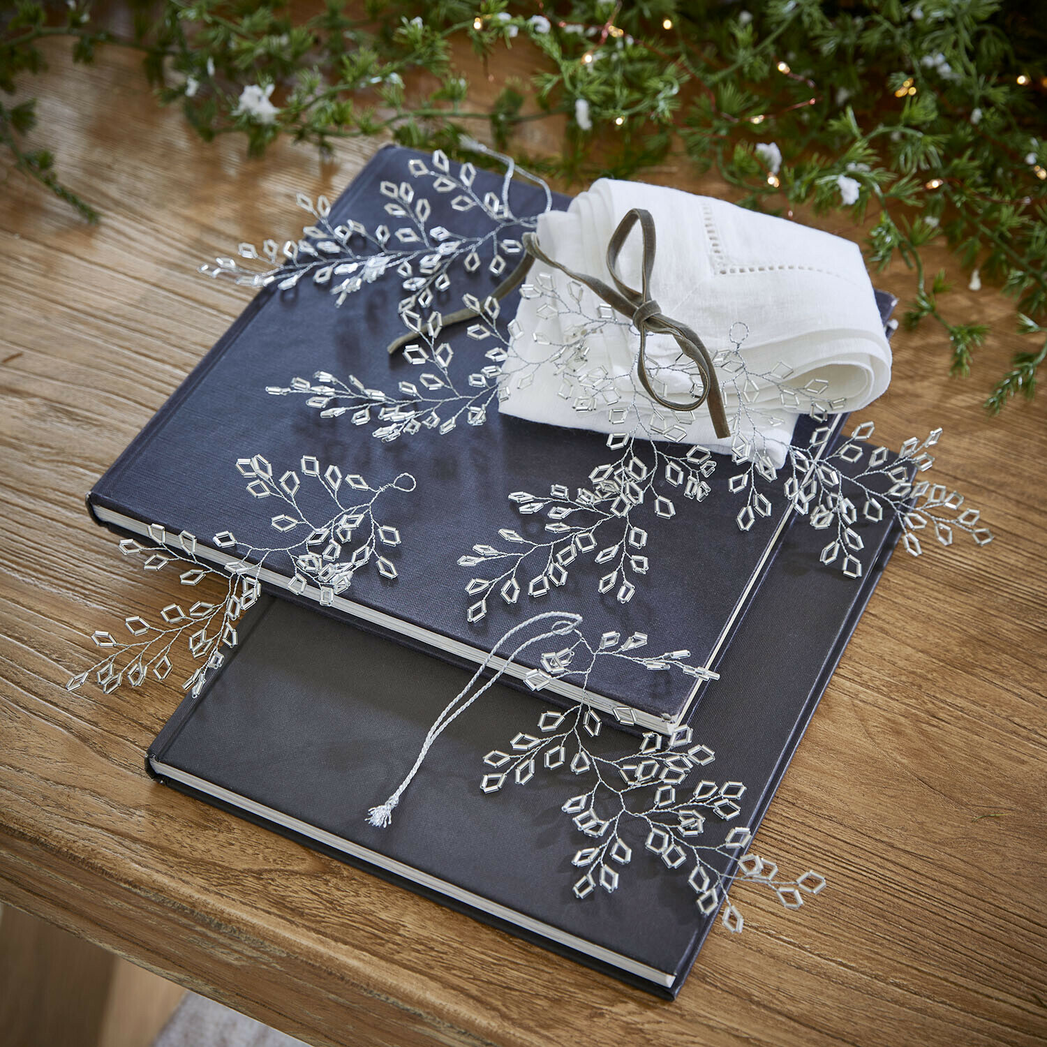 Ornament set van 6 Alruna Twee donkerblauwe en zwarte albums op houten tafel met witte linnen servet en kristaldecoratie