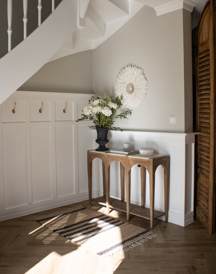 Natuurlijke beige-zwart gestreepte vloerkleed met franjes op lichte houten vloer in lichte hal