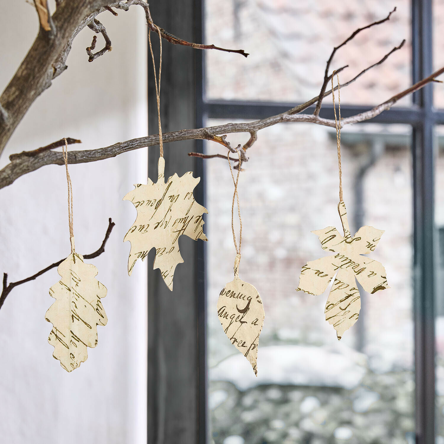 Hanger set van 4 Fleuriene Papieren bladdecoraties met tekst, hangend aan een tak voor een raam