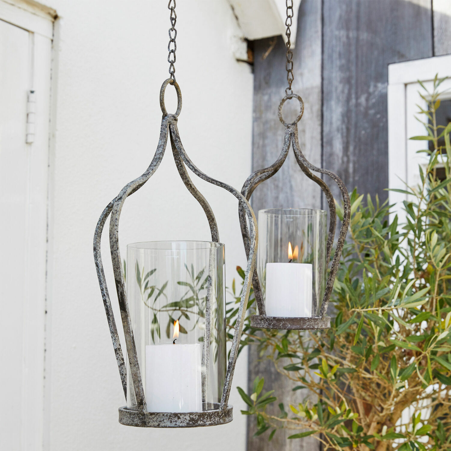 Hangende metalen lantaarns in vintage stijl met witte kaarsen en glas voor tuindecoratie