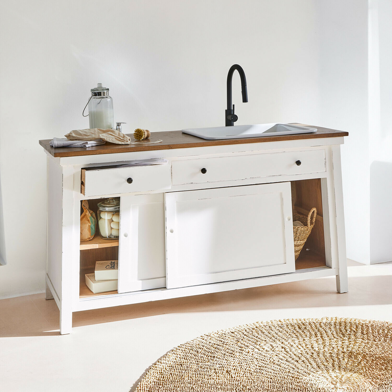 Witte houten kast met donker houten blad, witte wasbak en zwarte kraan, open lades