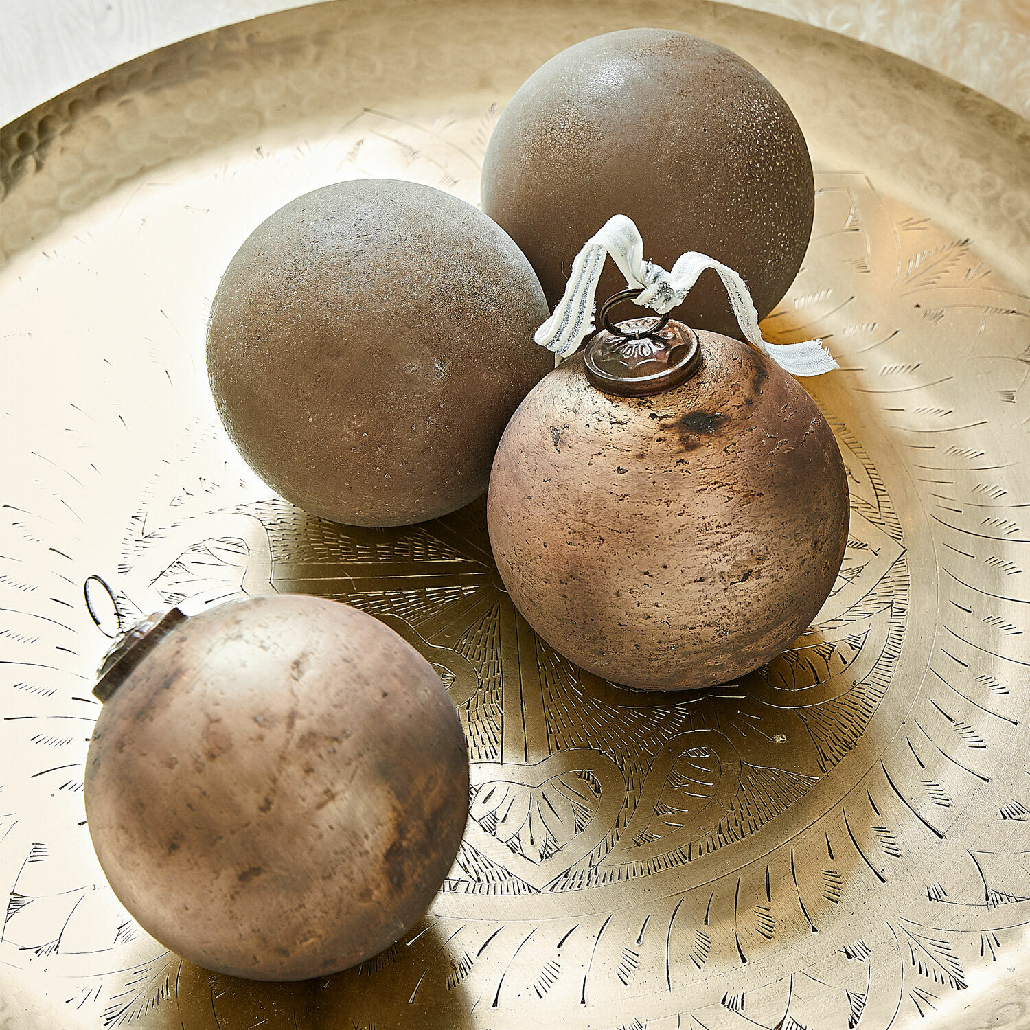 Kerstversiering set van 4 Ophraine Vier decoratieve bruine bollen op een gegraveerd messing dienblad met fijn patroon