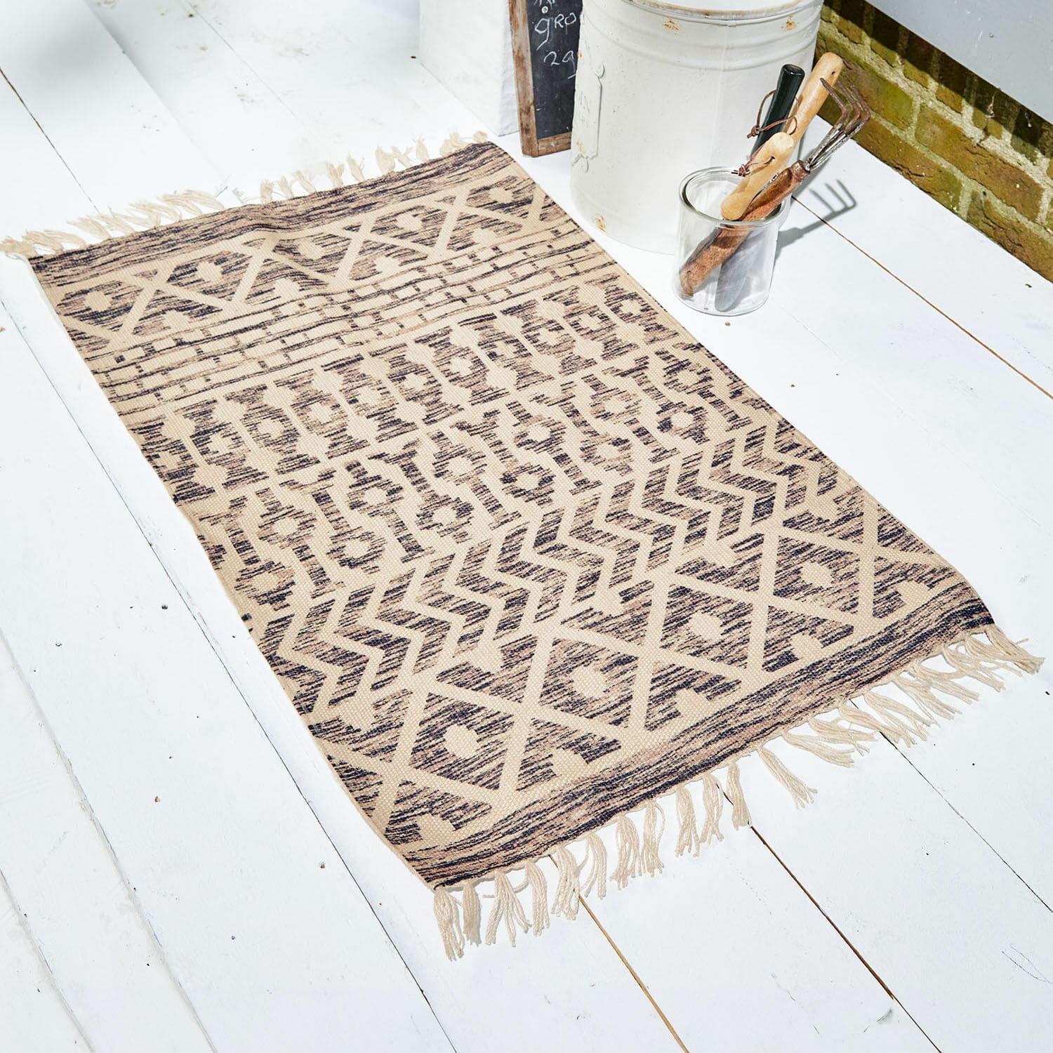 Deurmat voor binnen en buiten Champigny Beige vloerkleed met geometrisch patroon en franjes op witte vloer, interieurdecoratie