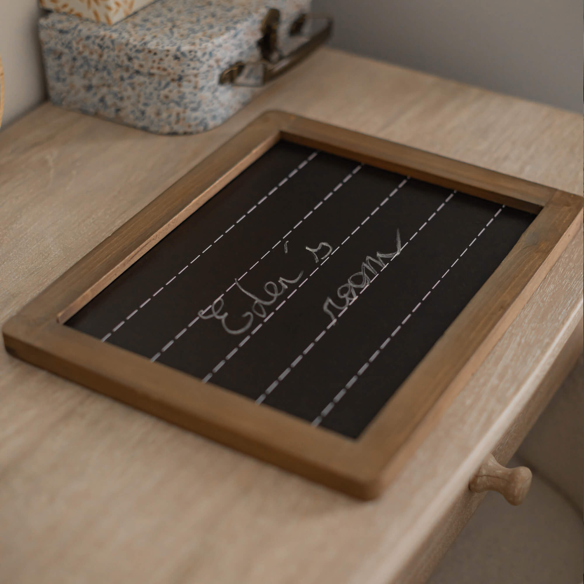 Krijtbord met houten lijst op lichte houten tafel, decoratief woonaccessoire