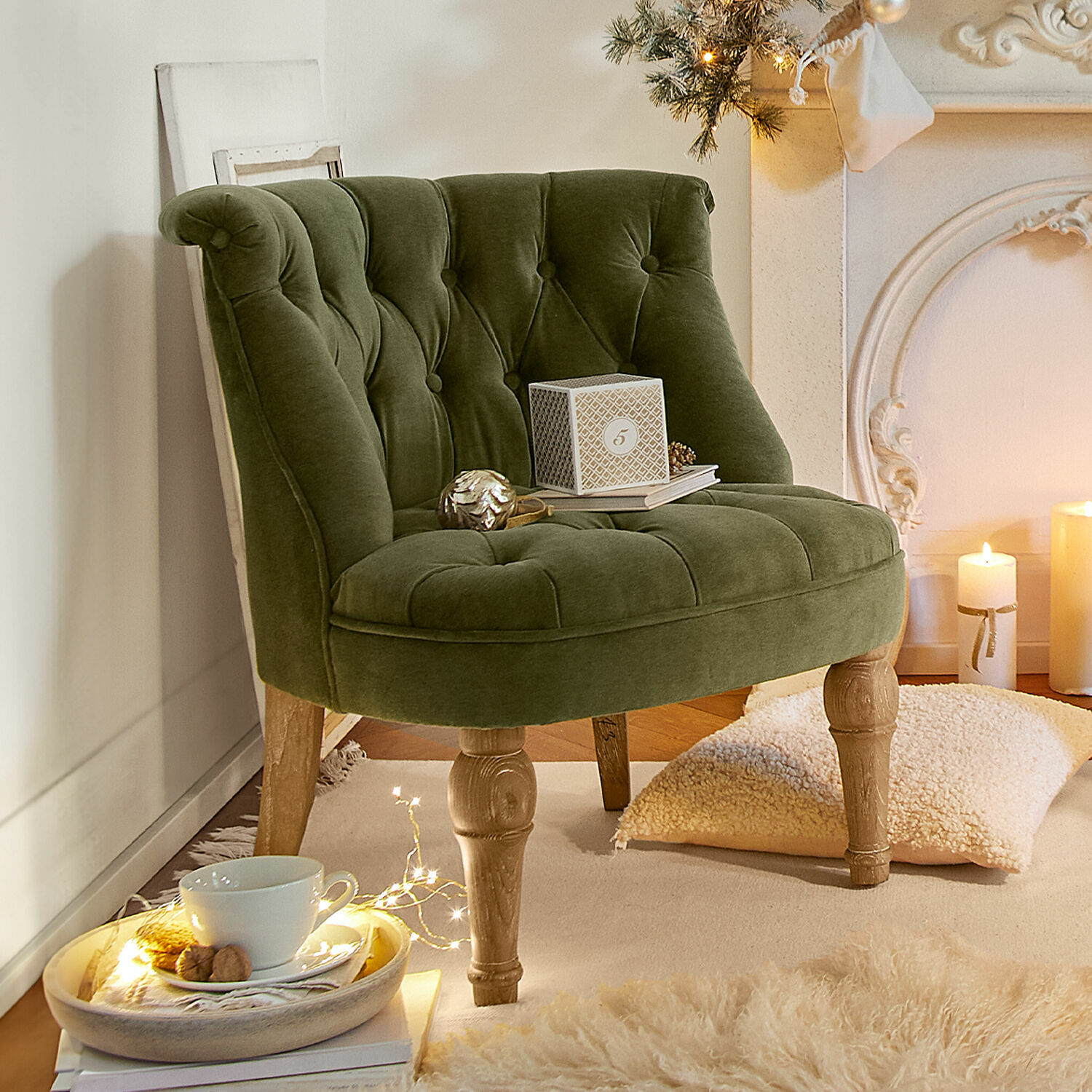 Groene fluwelen fauteuil met houten poten in gezellige kamer met kerstdecoratie