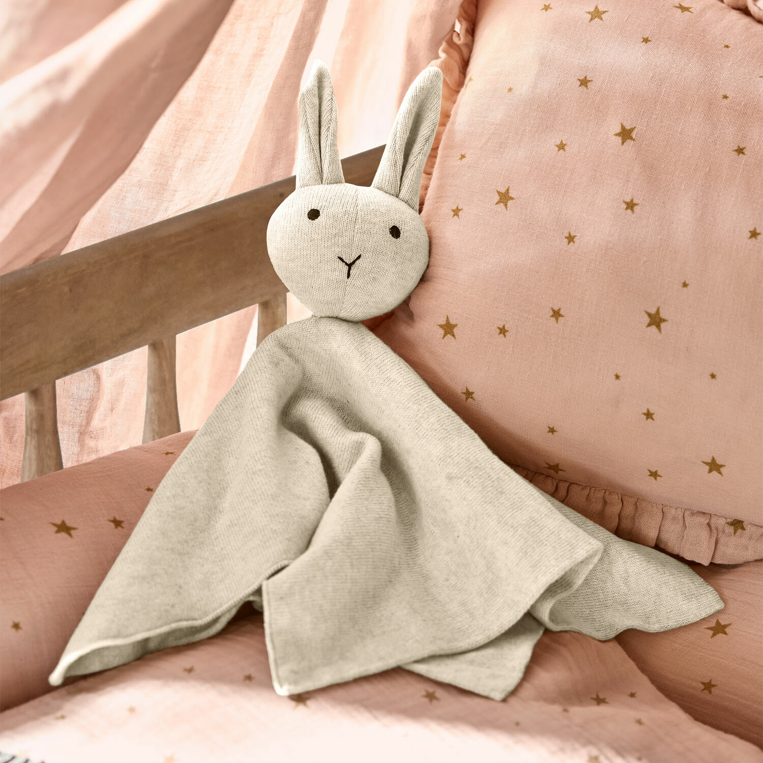 Knuffeldier Lumiou Zachte grijze stoffen konijnenknuffel op roze beddengoed met sterren, kinderkamerdecoratie