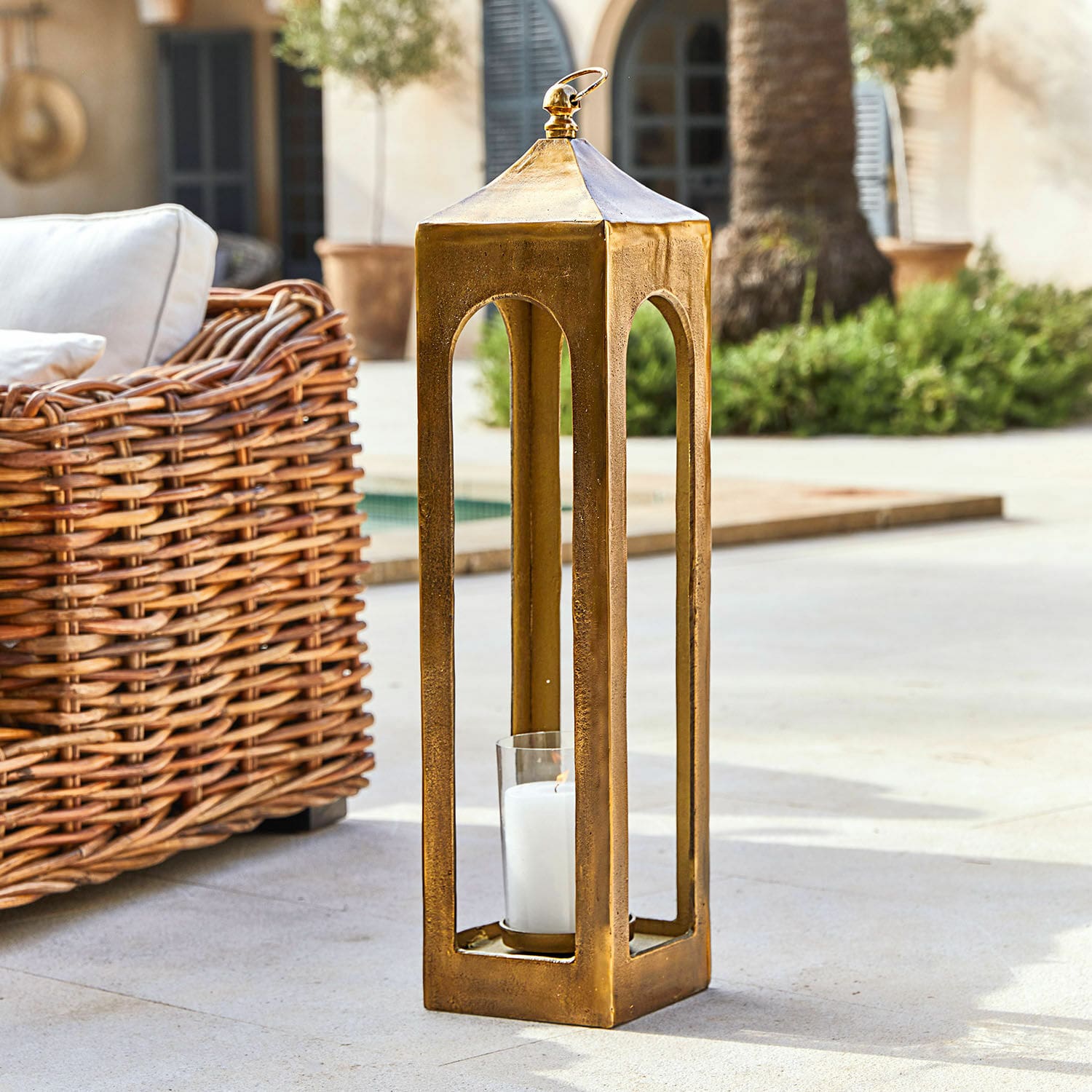 Gouden metalen lantaarn met witte kaars, buitendecoratie voor terras of patio