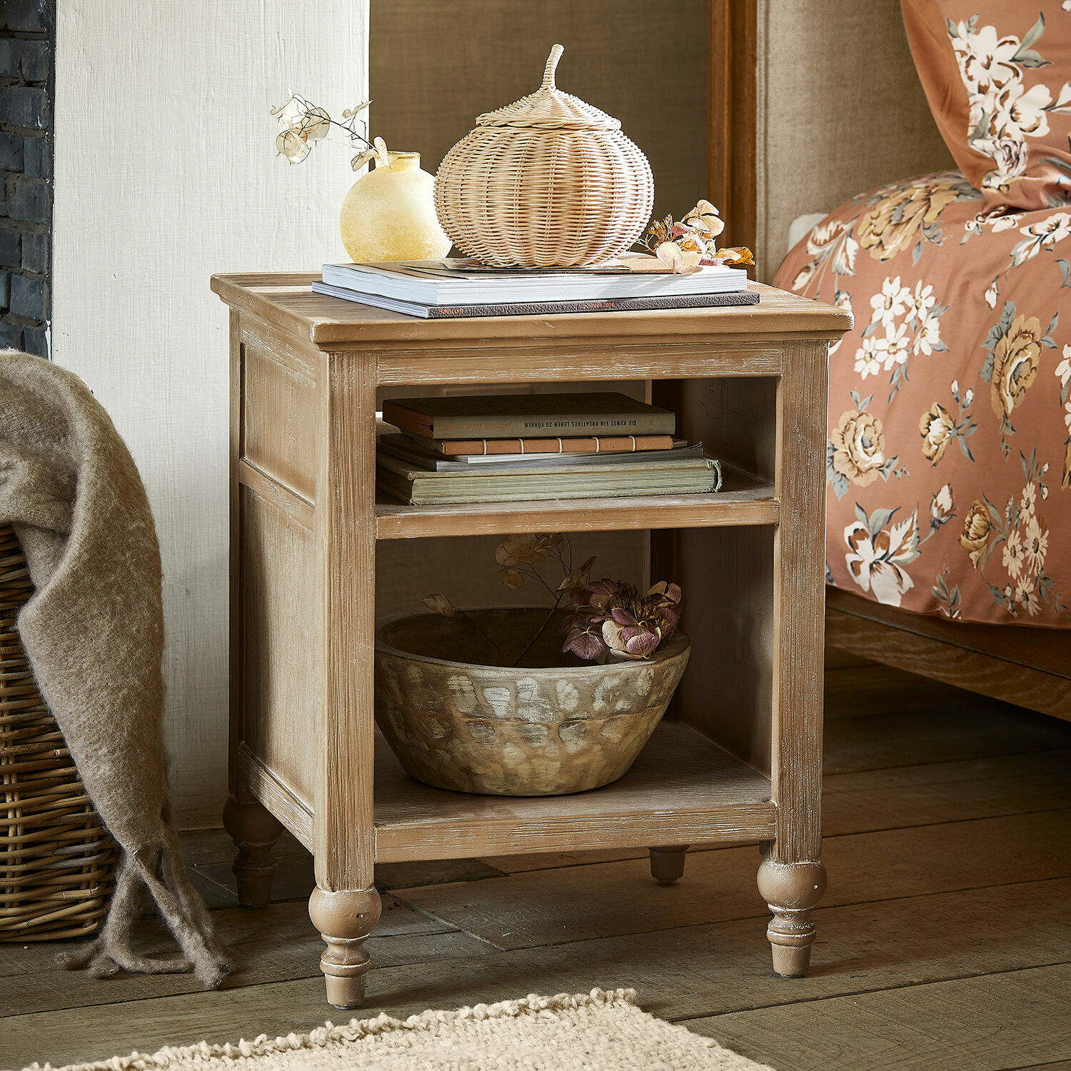 Houten nachtkastje in natuurlijke kleur met planken en decoraties in slaapkamer