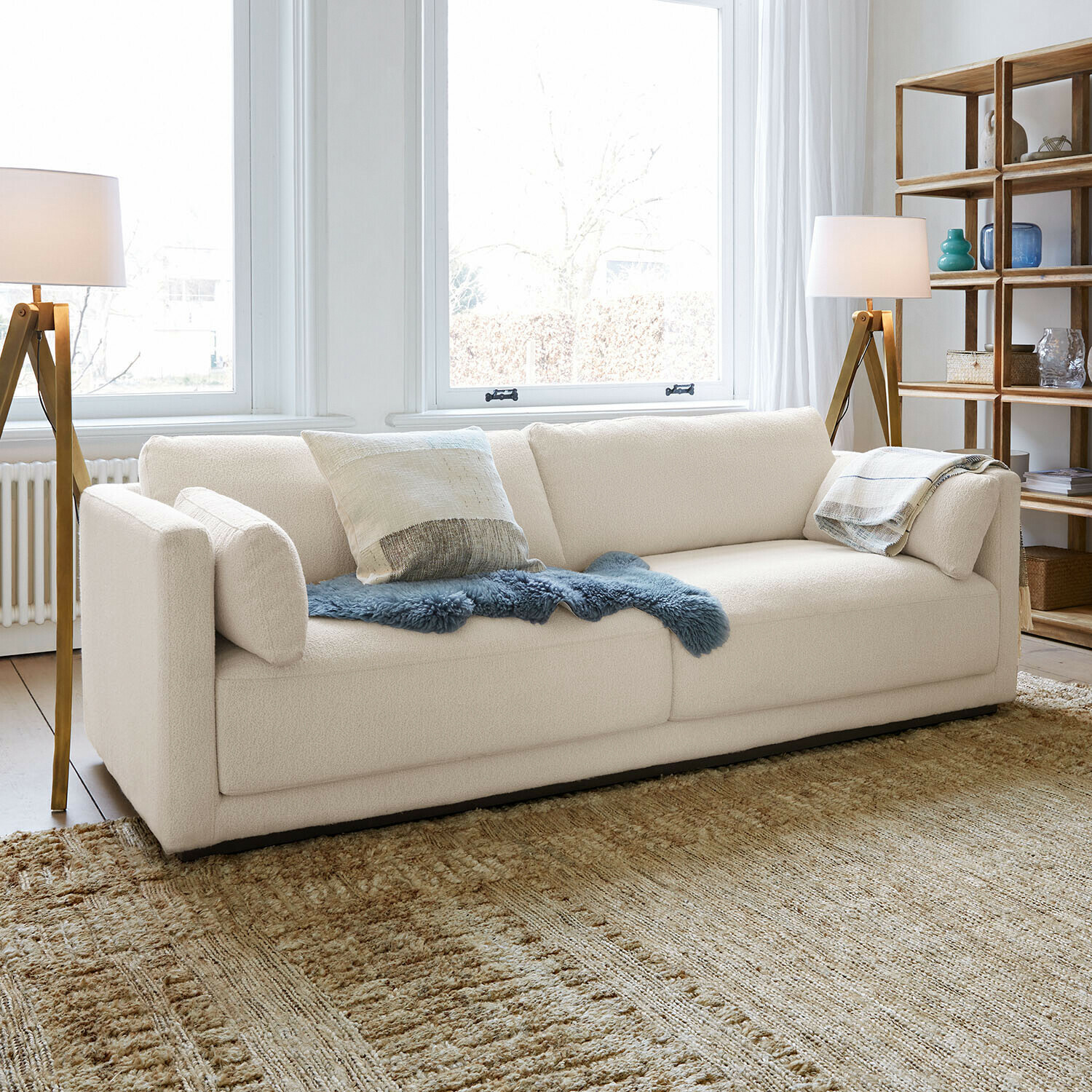 Bank Thamira Moderne crèmekleurige bank met zachte stof en decoratieve kussens in lichte woonkamer