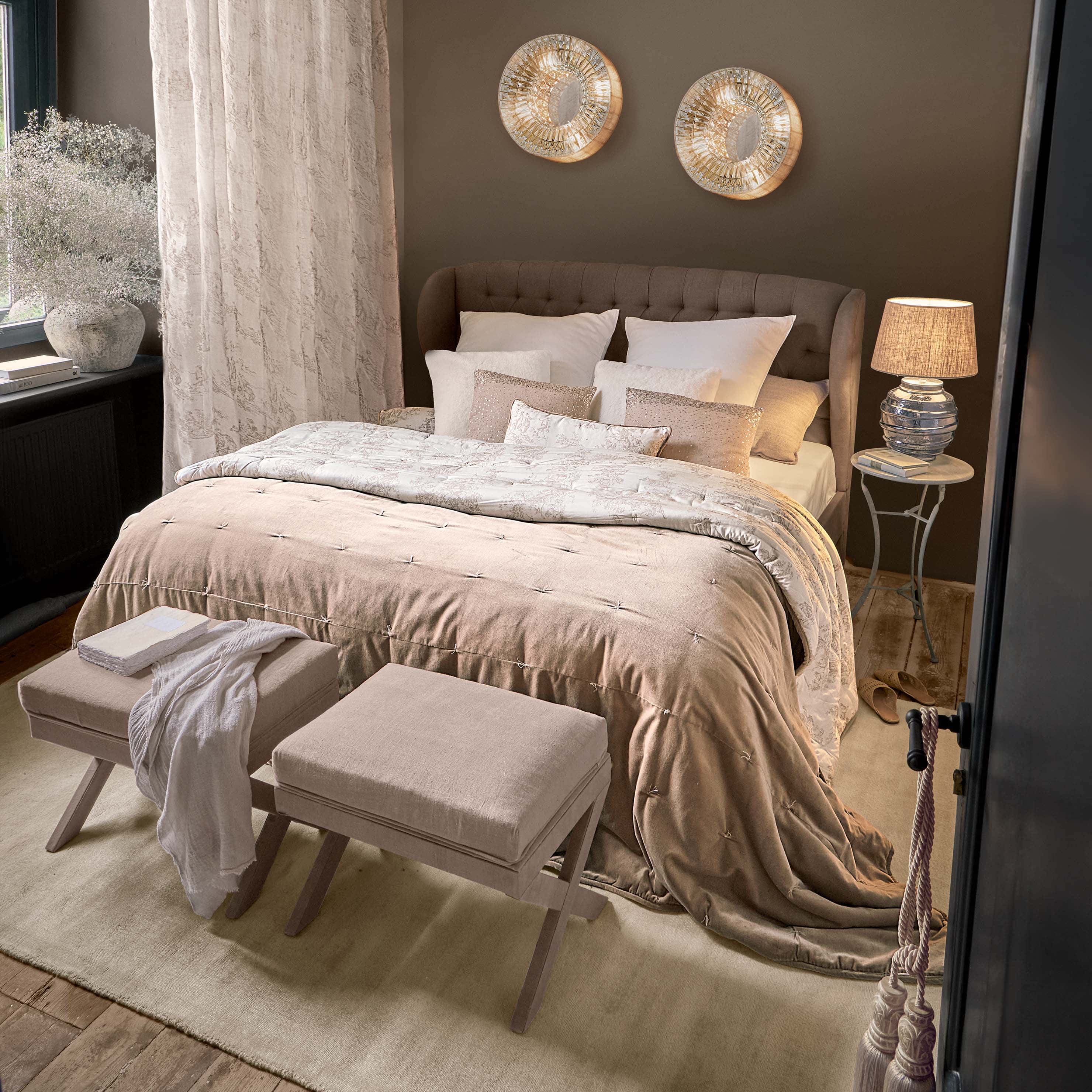 Gezellige slaapkamer met bruin gestoffeerd bed en beige beddengoed met decoratieve kussens