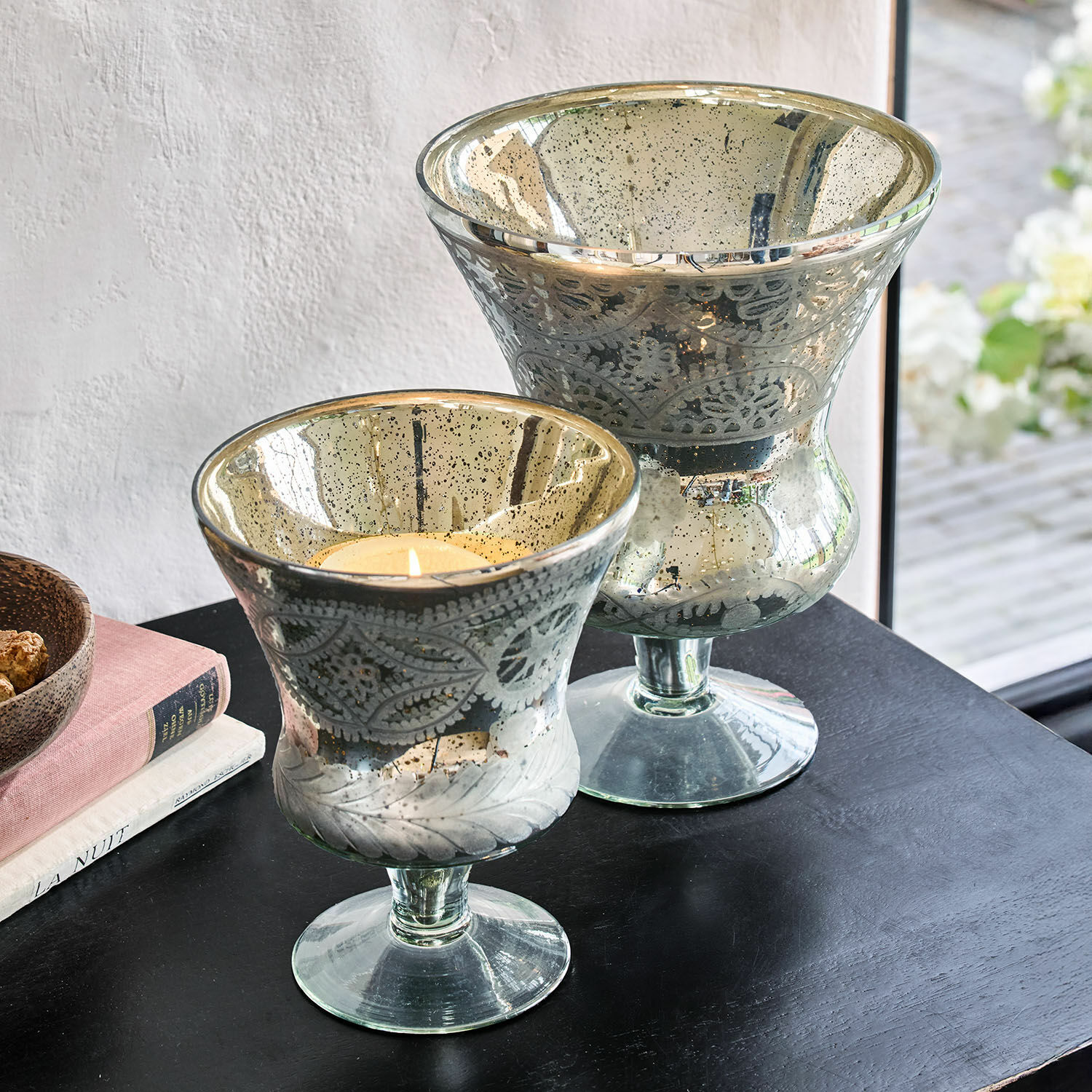 Windlicht set van 2 Zorayne Twee decoratieve glazen windlichten met bladmotief en zilveren afwerking op een zwarte tafel
