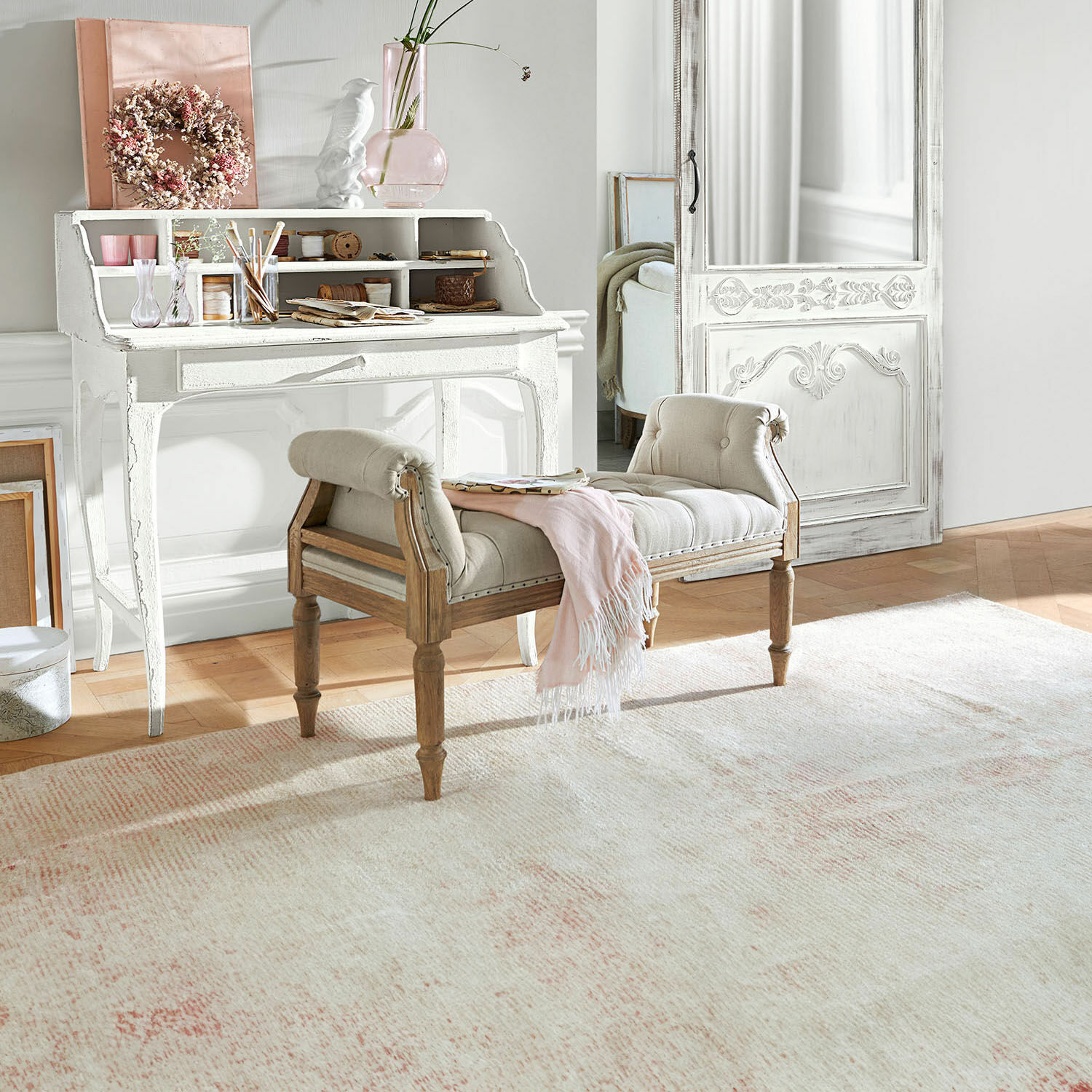 Gestoffeerde bank van licht hout en beige stof in lichte kamer met lichte vloerkleed