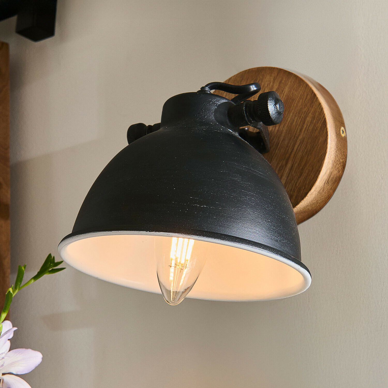 Zwarte metalen wandlamp met houten basis en warm LED-licht voor industriële interieurs