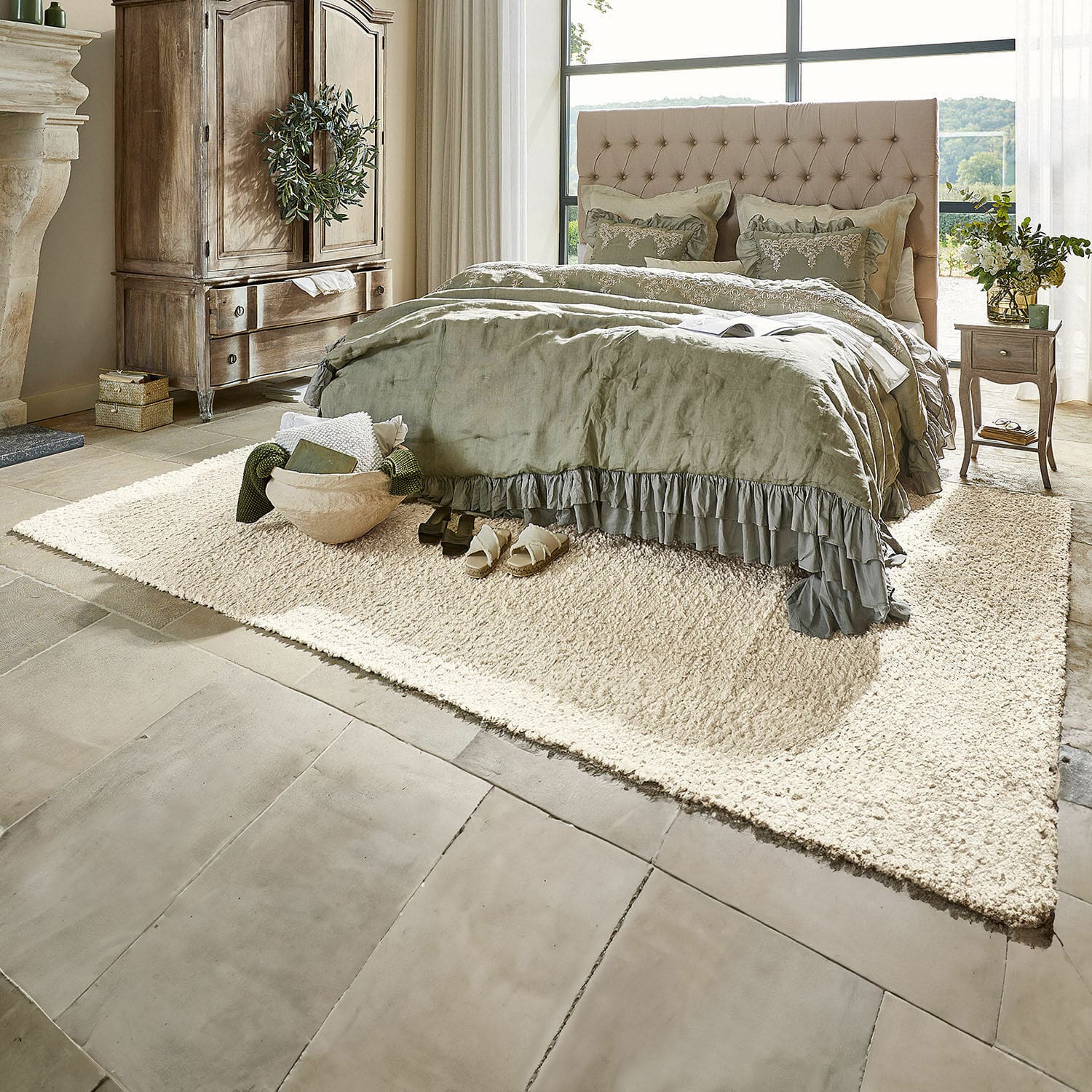 Vloerkleed Wodaha Gezellige slaapkamer met beige gestoffeerd bed en groene beddengoed op crèmekleurig zacht tapijt