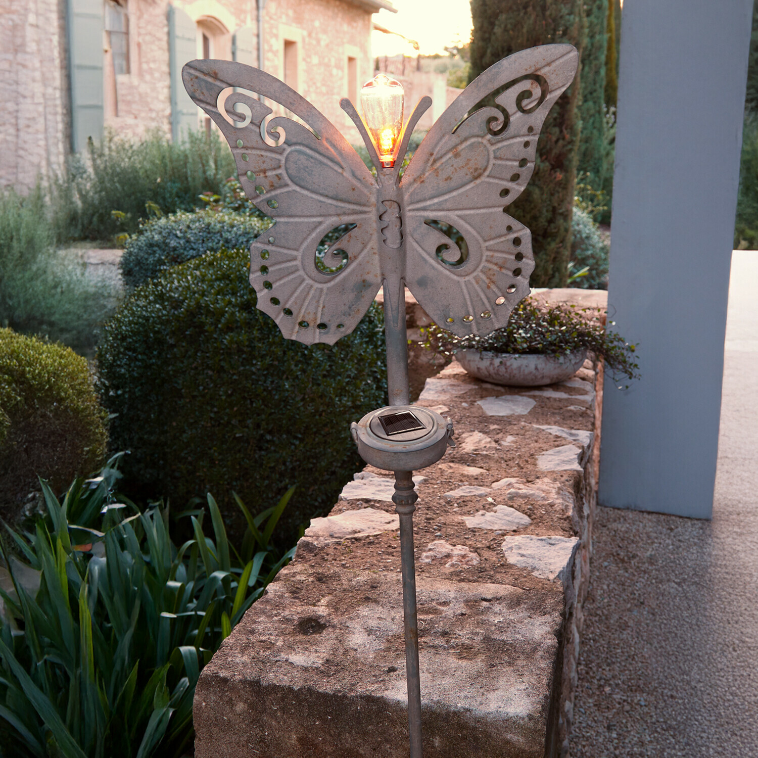 Tuinlamp in de vorm van een vlinder van grijs metaal met zonnepaneel en brandende LED-lamp