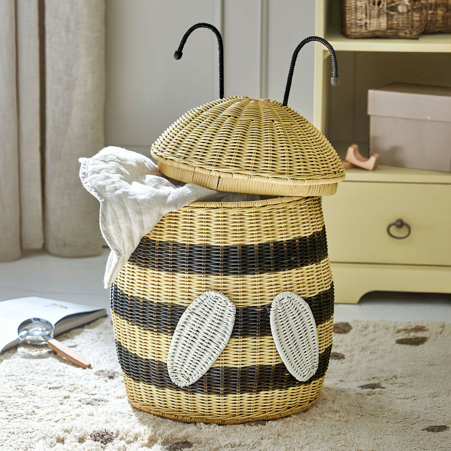 Wasmand van riet in bijenvorm met natuurlijke en zwarte strepen voor kledingopslag