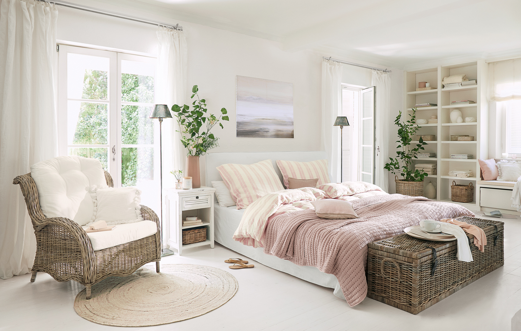 Gezellige landelijke slaapkamer met rotan stoel en roze beddeken