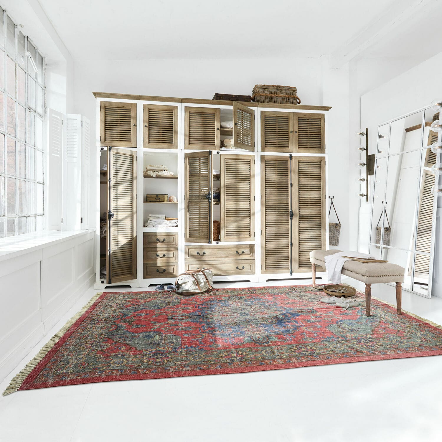 Vloerkleed Southampton Groot rood tapijt met oosters patroon op witte vloer in lichte kamer met houten kast
