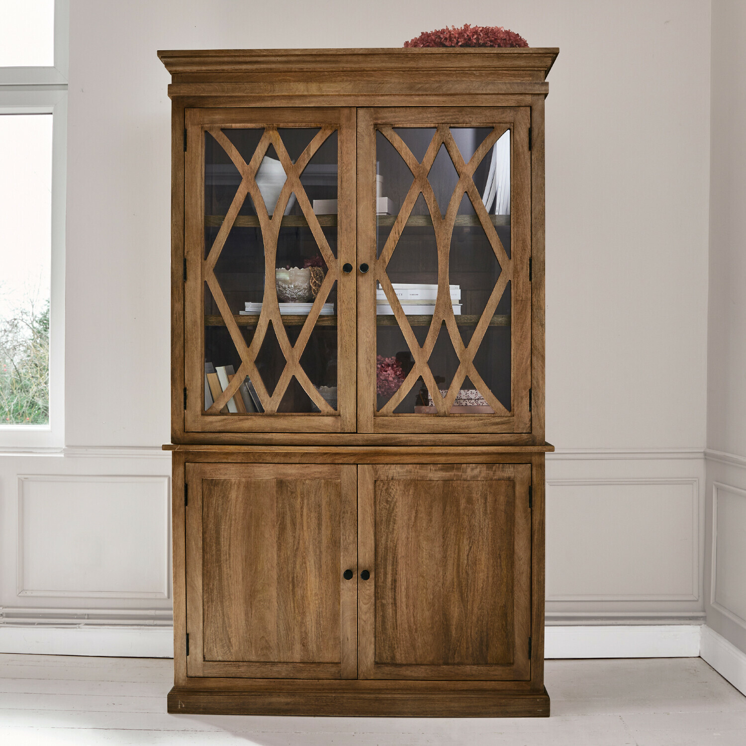 Houten vitrinekast met decoratieve glazen deuren en onderkant van massief hout in natuurlijke kleur