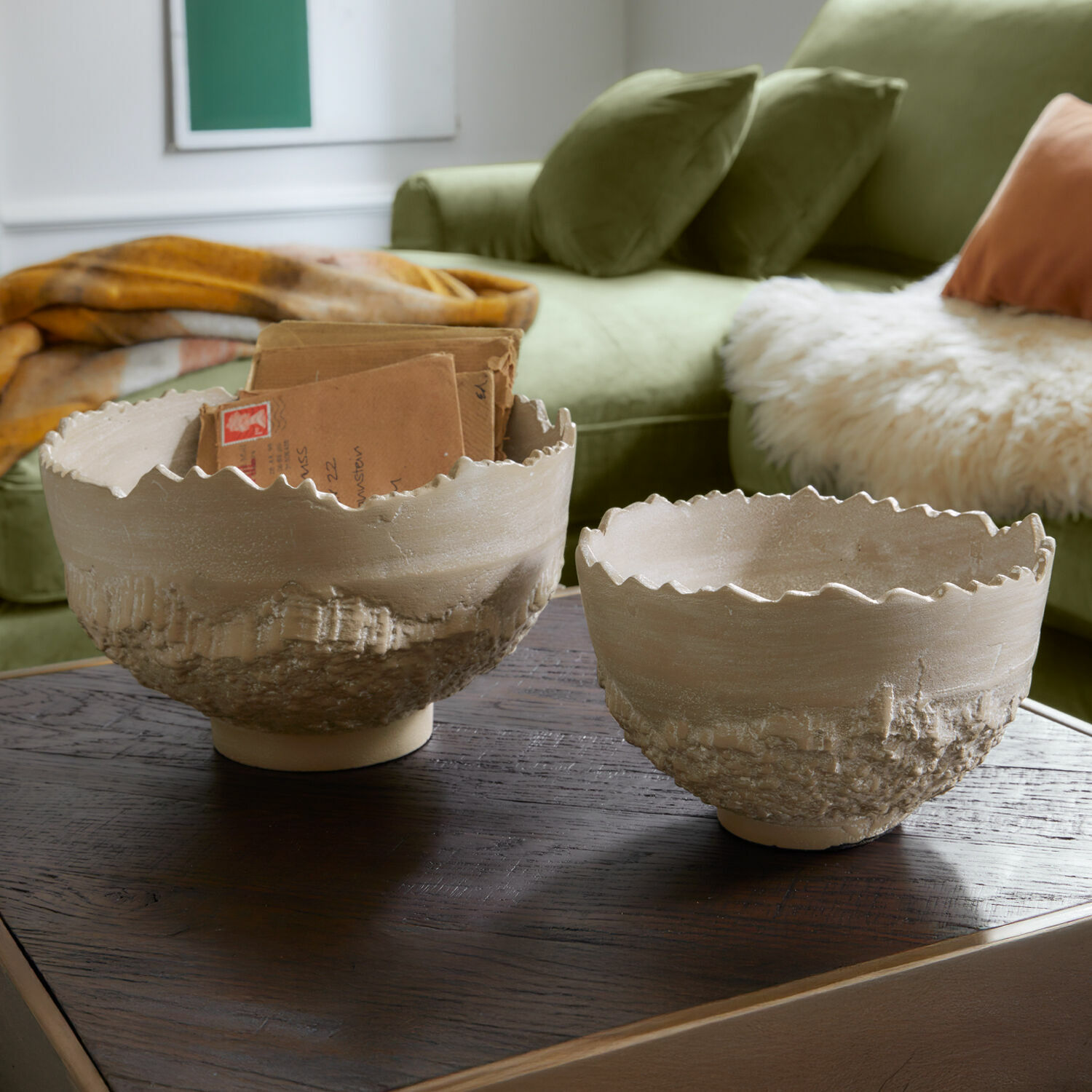 Schaal set van 2 Alvendra Twee beige keramische kommen met ruwe textuur en golvende rand op een houten tafel