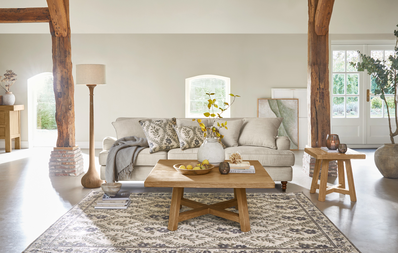 Gezellige landelijke woonkamer met beige bank, houten salontafel en natuurlijk patroon vloerkleed