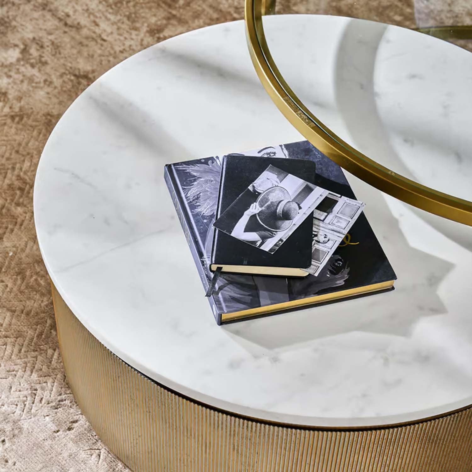 Ronde salontafel met wit marmeren blad en gouden onderstel op beige tapijt