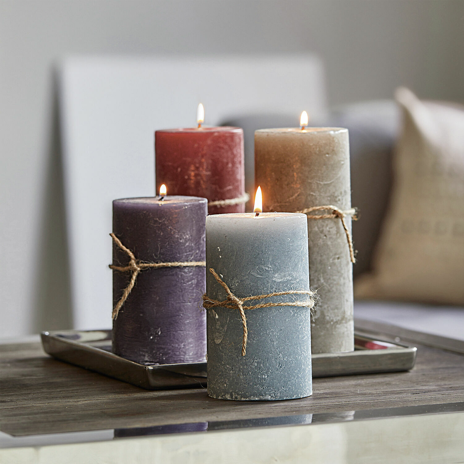 Kaars set van 4 Berekua Set van vier decoratieve kaarsen in verschillende kleuren met natuurlijke touw op houten tafel