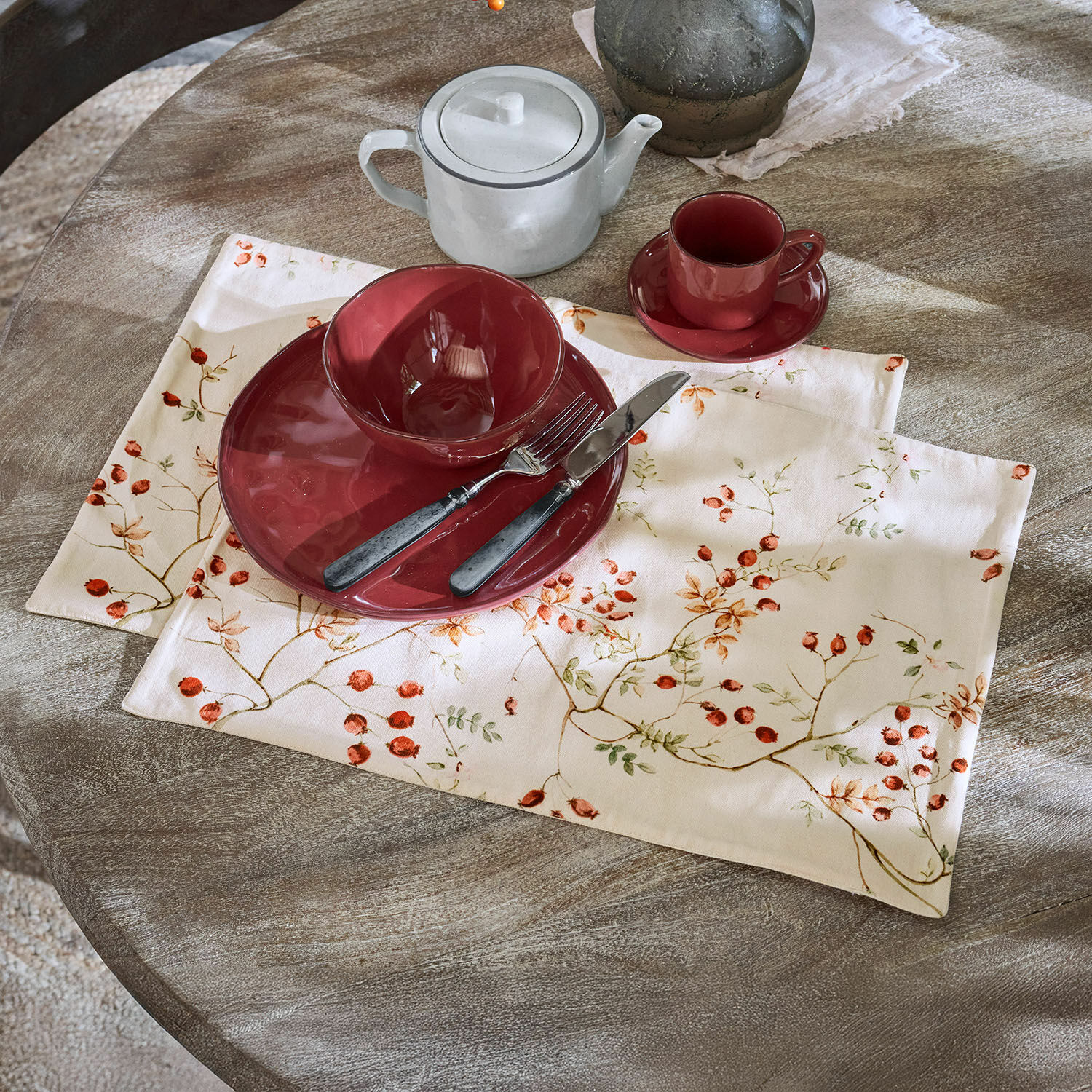 Placemat set van 2 Mauriac Rood keramisch servies op linnen placemat met fruitmotief op rustieke houten tafel