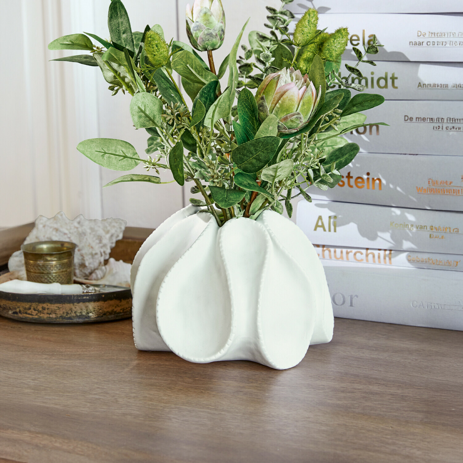 Siervaas Dollon Witte keramische vaas met groene bladeren en decoratieve bloemen op houten tafel
