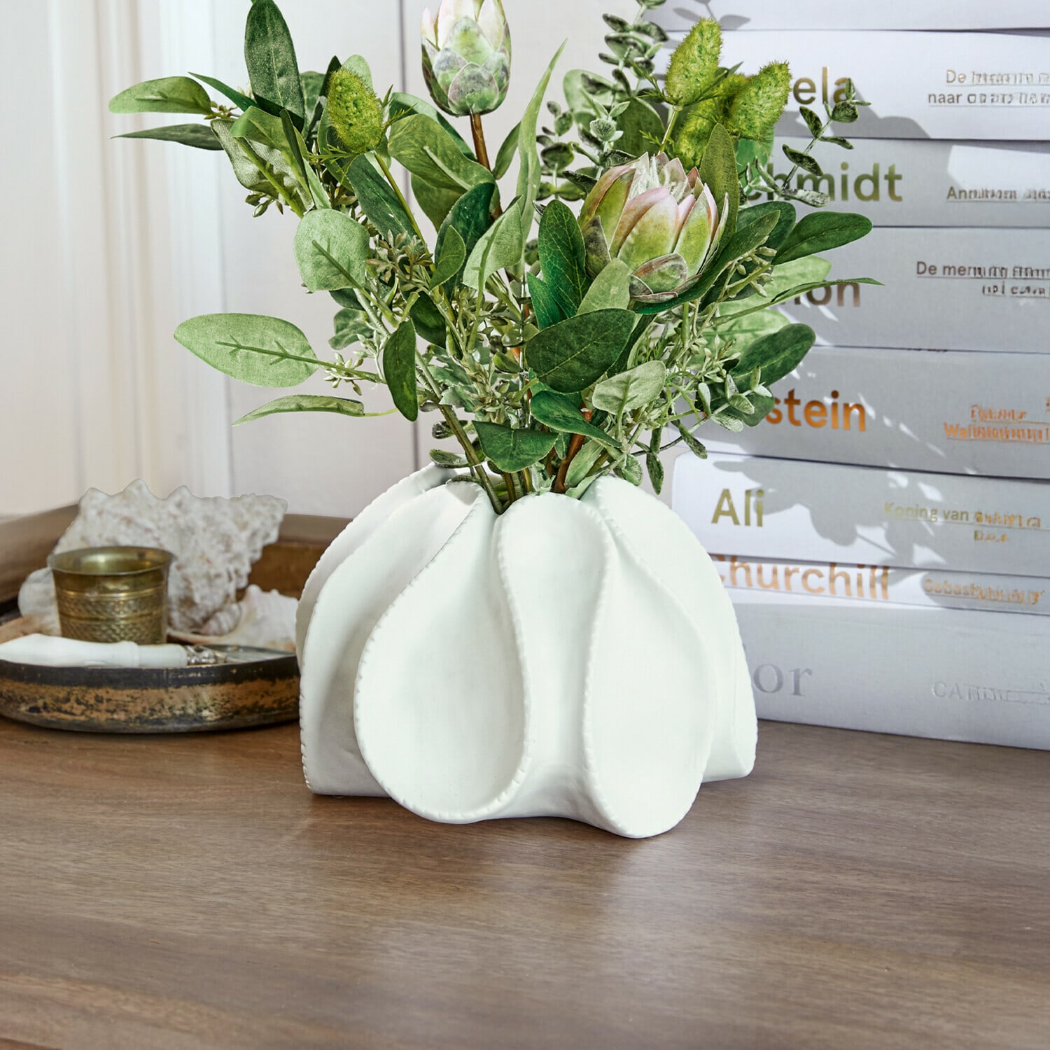 Siervaas Dollon Witte keramische vaas met groene bladeren en decoratieve bloemen op houten tafel