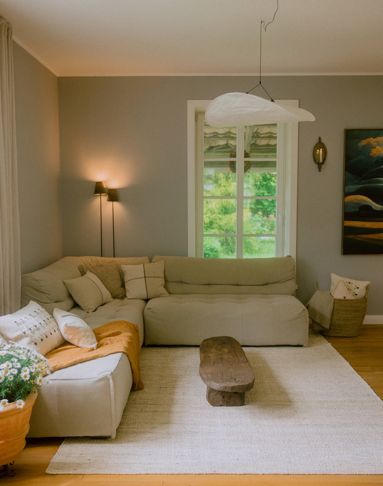 Gezellige woonkamer met beige hoekbank, houten salontafel en natuurlijke vloerkleed in Scandinavische stijl