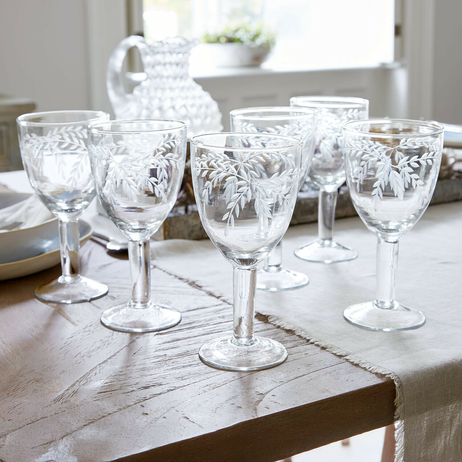 Glas set van 6 Florineau Set van zes heldere glazen met wit bladmotief op een eettafel