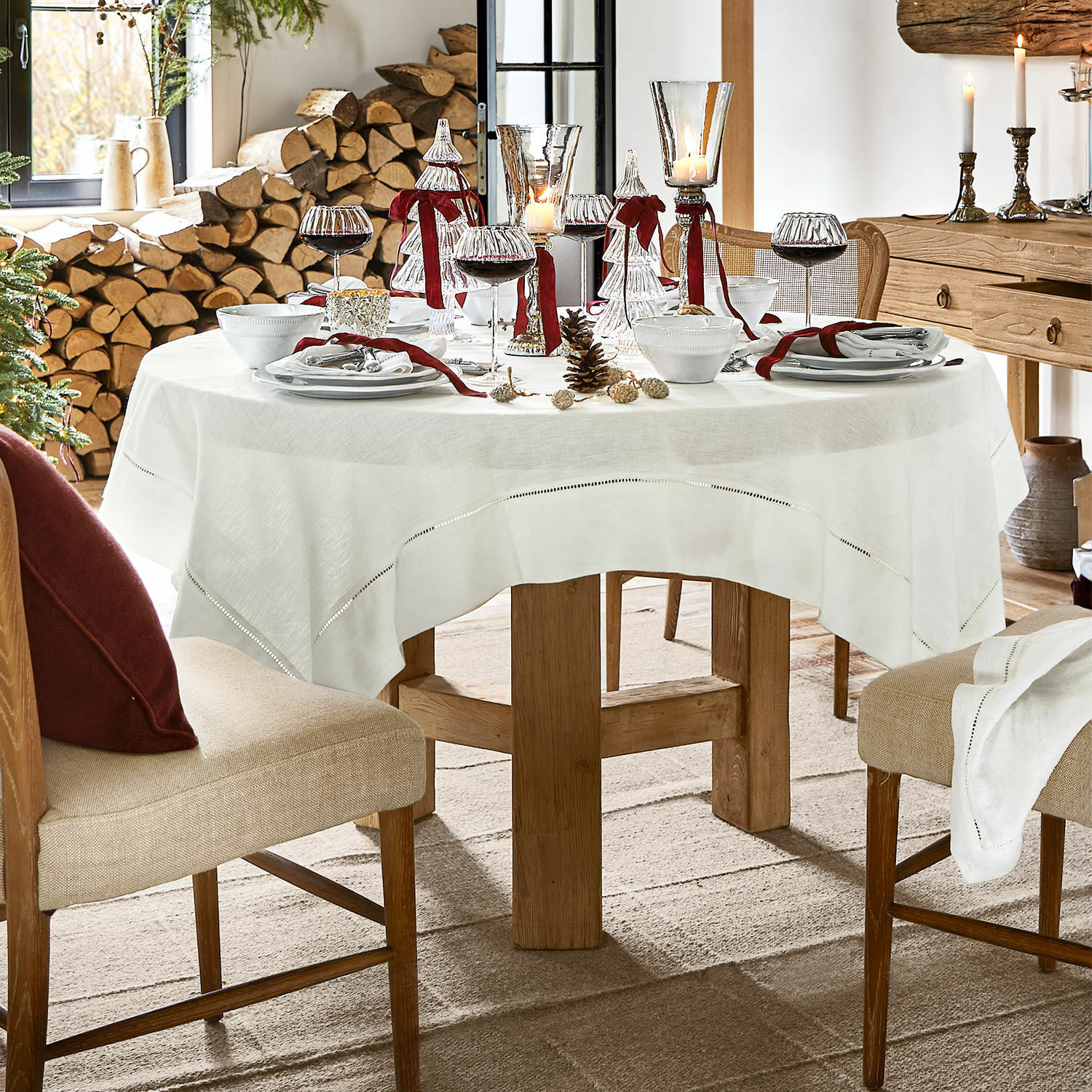 Tafelkleed Covent Garden Ronde tafel met wit linnen tafelkleed en kerstdecoratie in rustieke houten interieur
