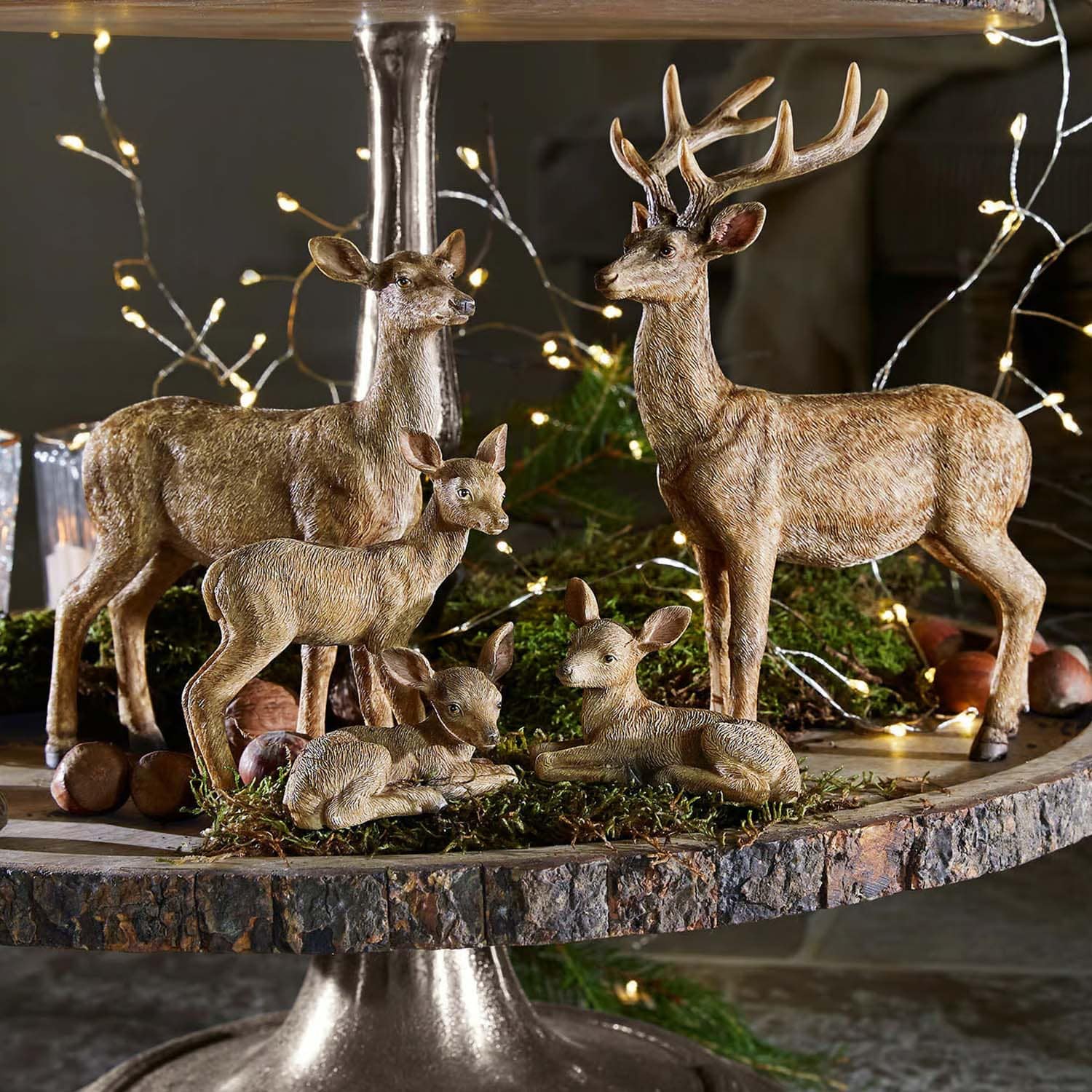 Set decoratieve hertenfiguren van bruin kunststof op een rustieke houten standaard voor interieurdecoratie