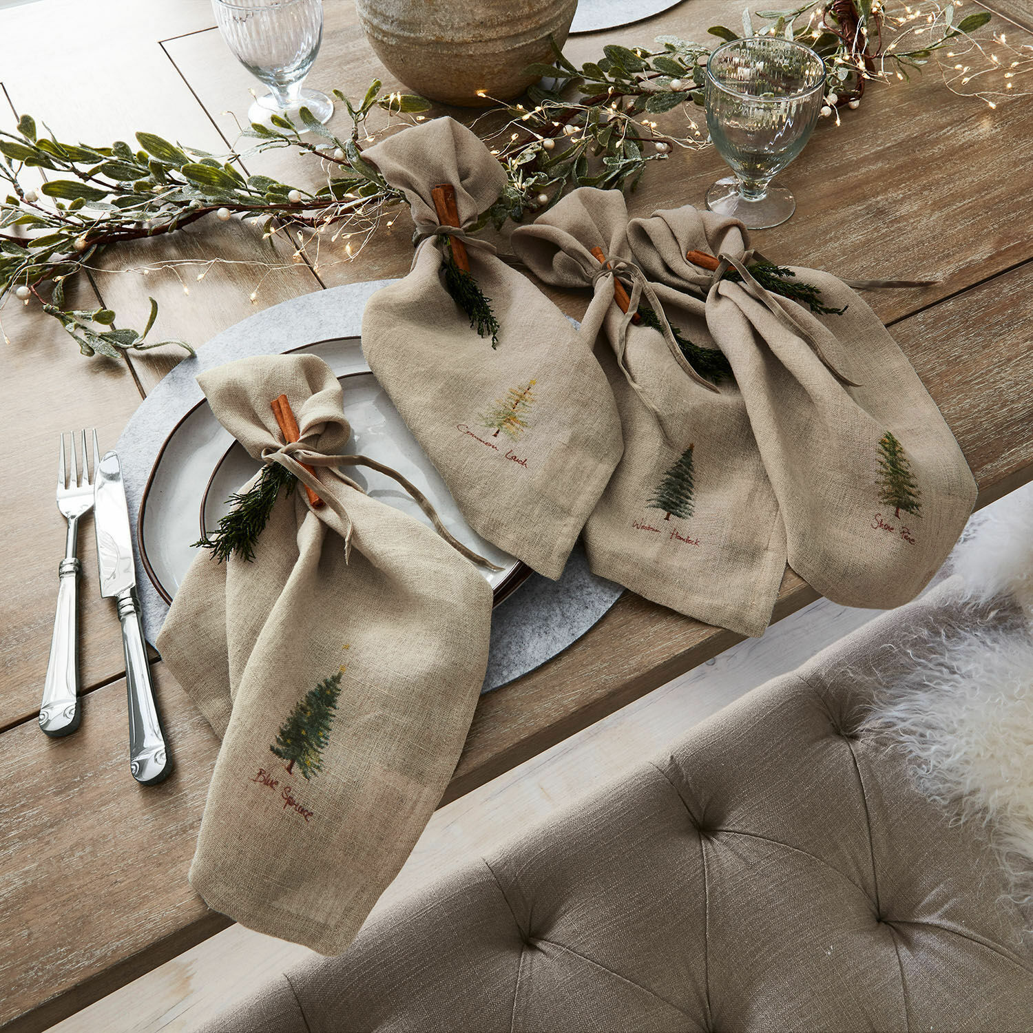 Servet set van 4 Jarrier Beige linnen servetten met boomprint en kaneelversiering op rustieke houten tafel