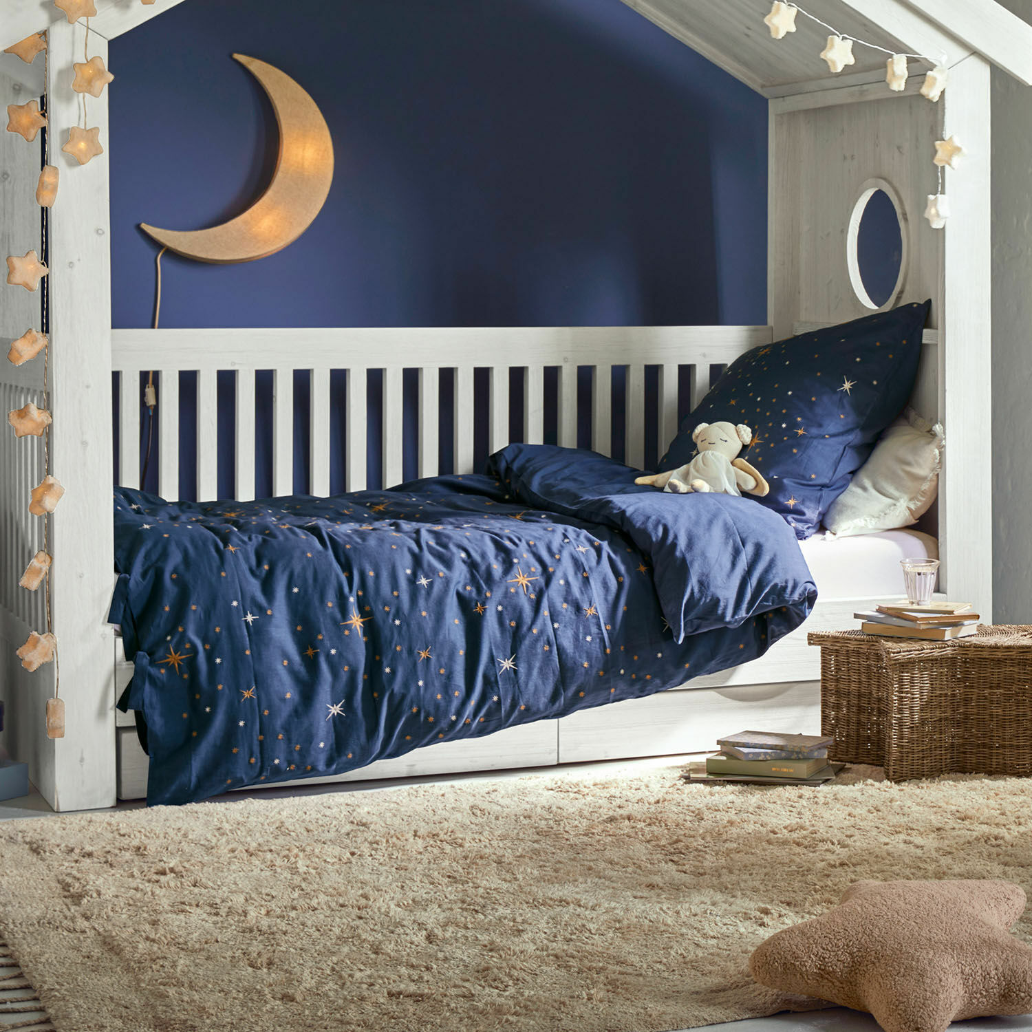 Beddengoed Starwhisper Witte houten kinderbed met donkerblauw sterrenbeddengoed en maanlamp voor een gezellige kinderkamer