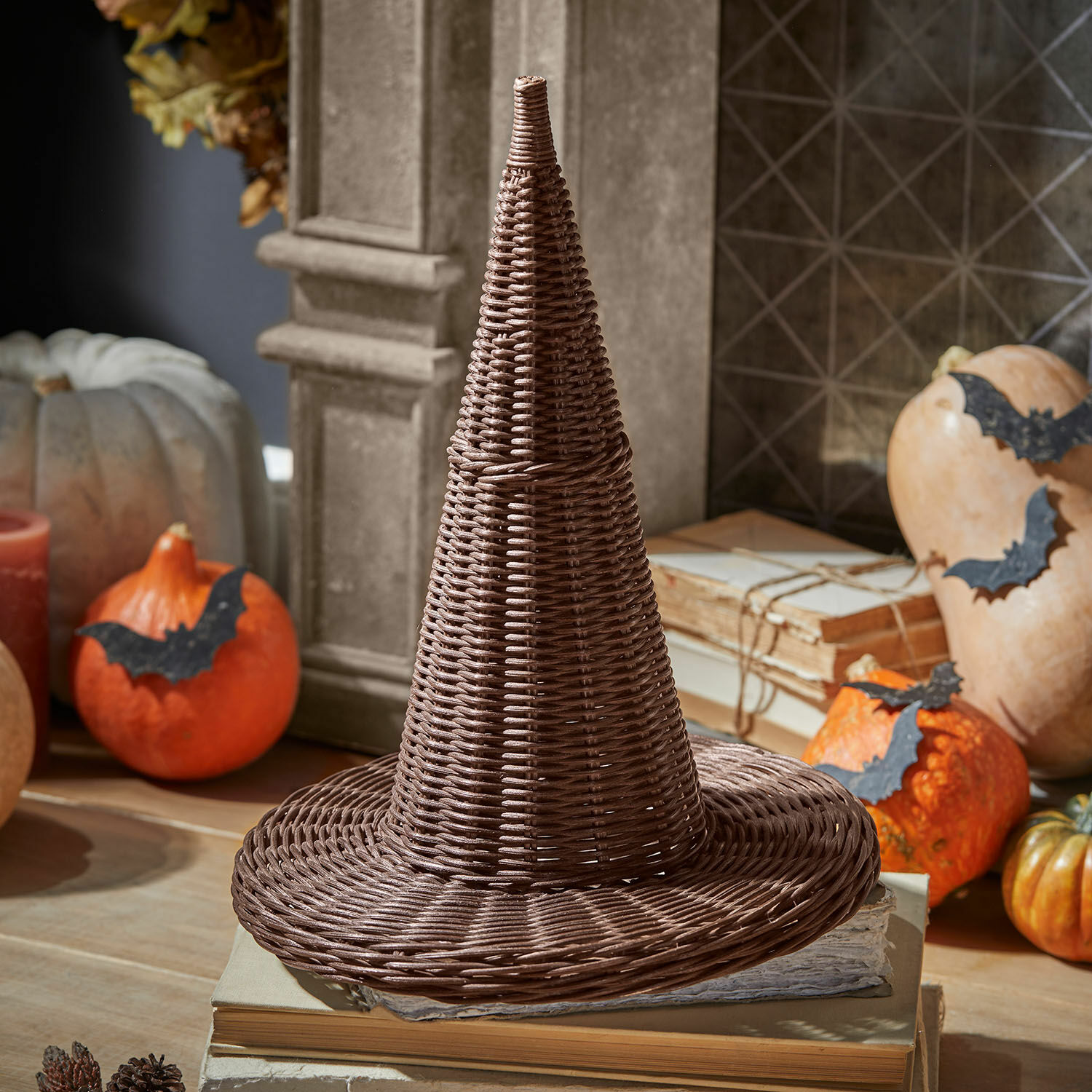 Sierhoed Halimad Bruine conische hoed van gevlochten wilg op boeken, herfstdecoratie met pompoenen en vleermuizen