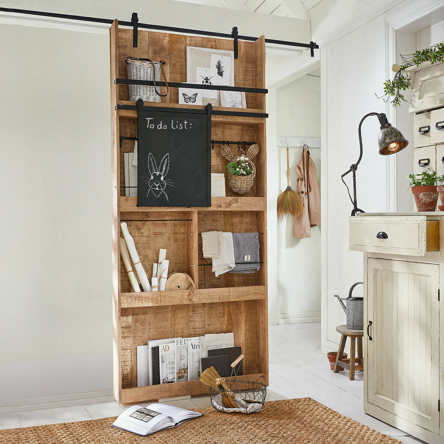 Schuifdeur Vulmont Houten kast met krijtbord en decoraties in lichte ruimte met jute vloerkleed