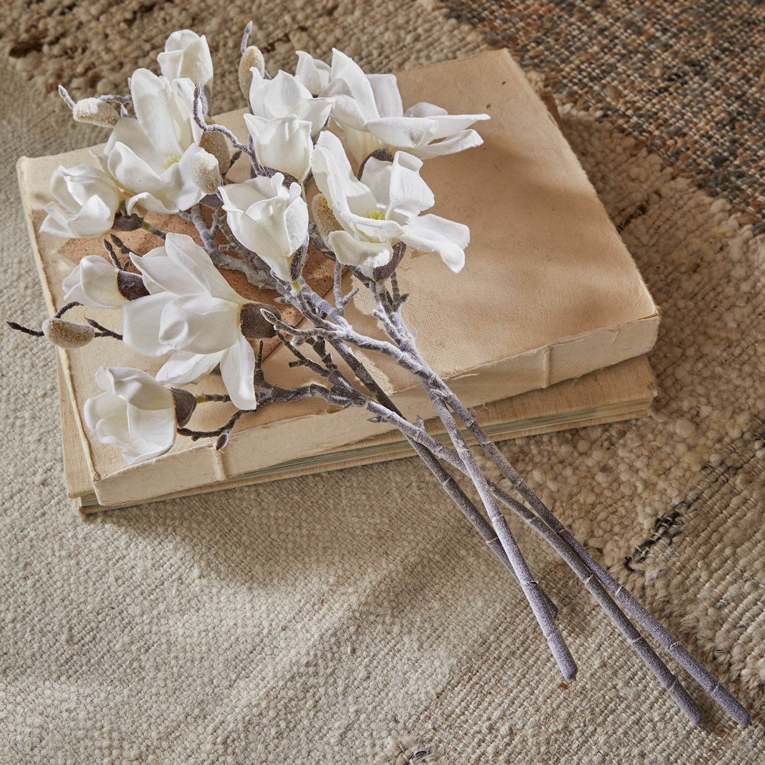Sierbloem set van 4 Santavella Boeket witte magnoliabloemen van stof op beige boeken op een gestructureerd tapijt