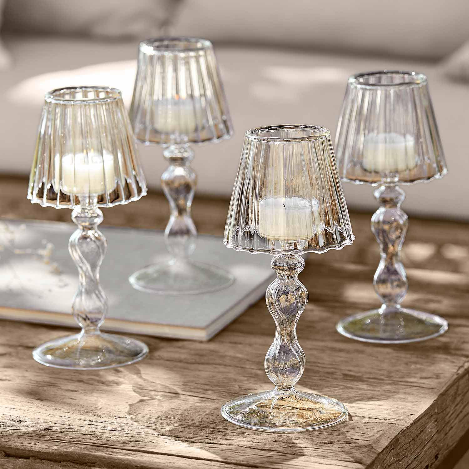 Transparante glazen kandelaren met witte kaarsen op houten tafel voor interieurdecoratie