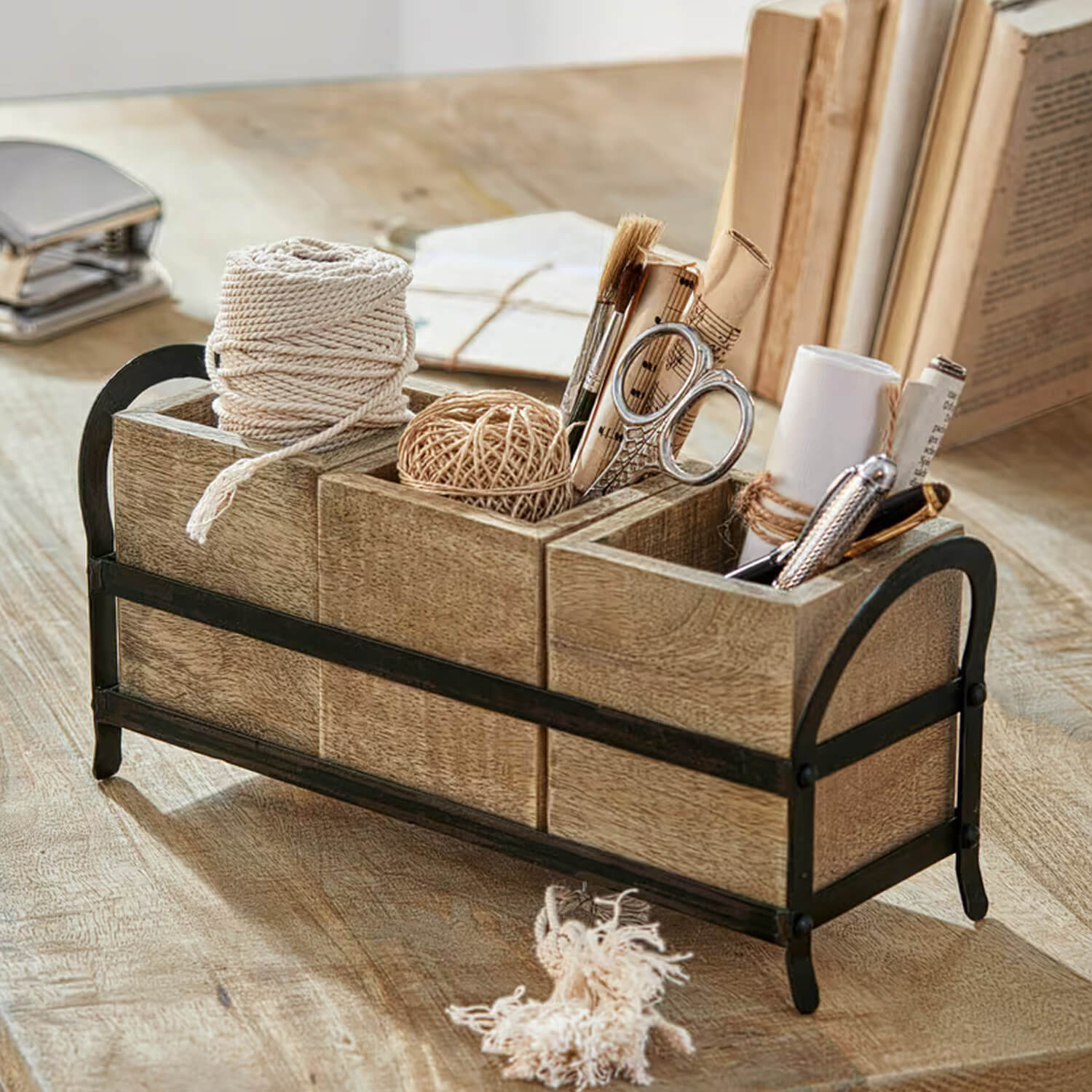 Houten bureau-organizer met drie vakken en metalen frame gevuld met schrijfwaren en touw