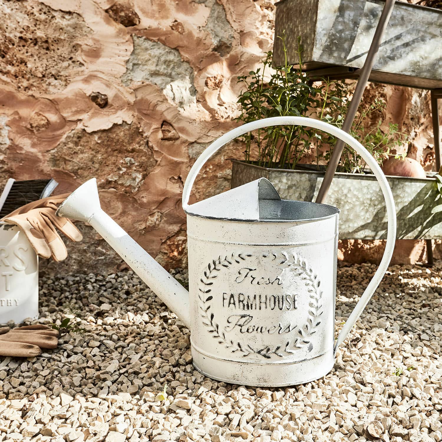 Gieter Farmhouse Witte metalen gieter met Farmhouse-opdruk op grindgrond voor tuinieren en planten water geven