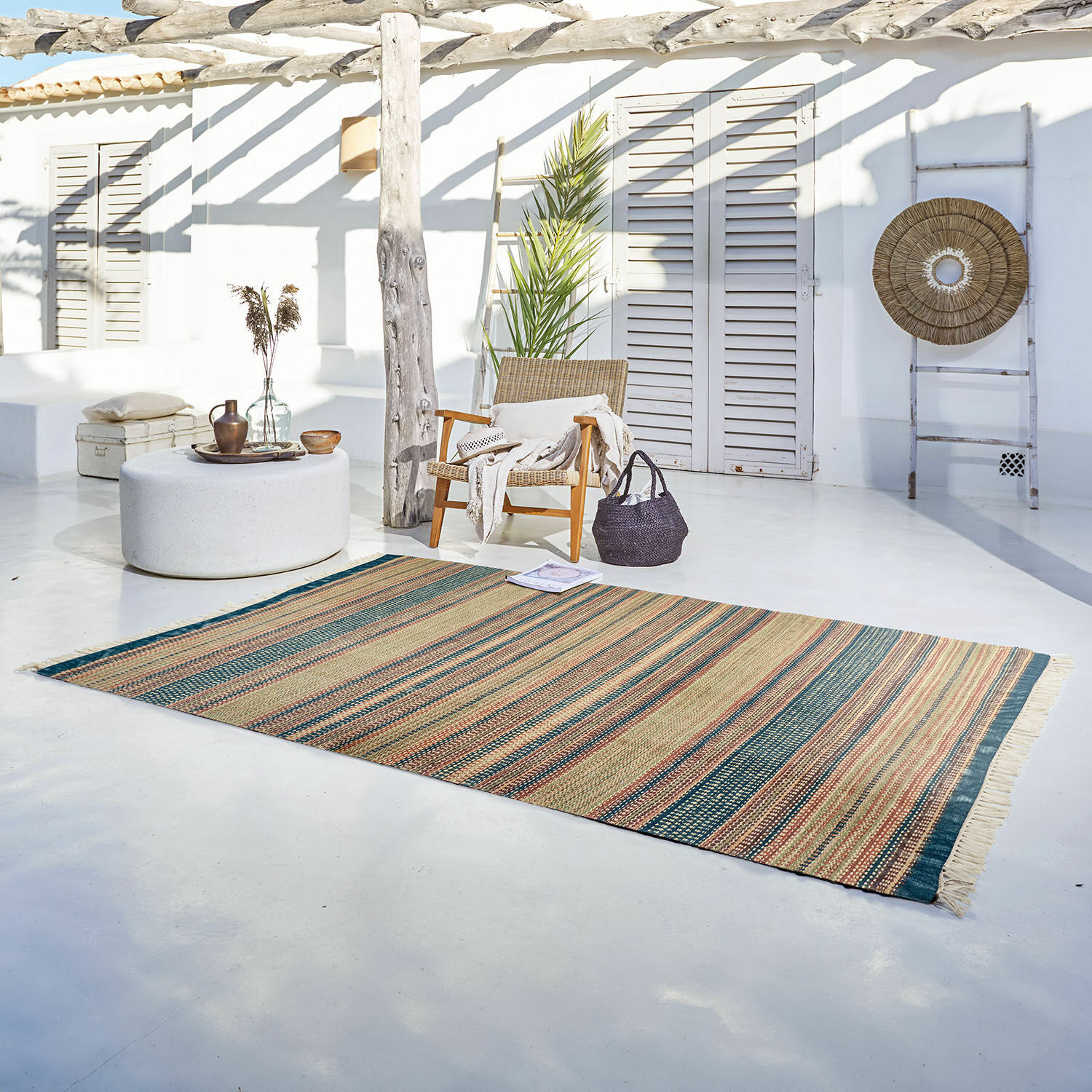 Vloerkleed voor binnen en buiten Atlanta Gestreept vloerkleed van natuurlijk materiaal in beige en groene tinten op lichte terrasvloer