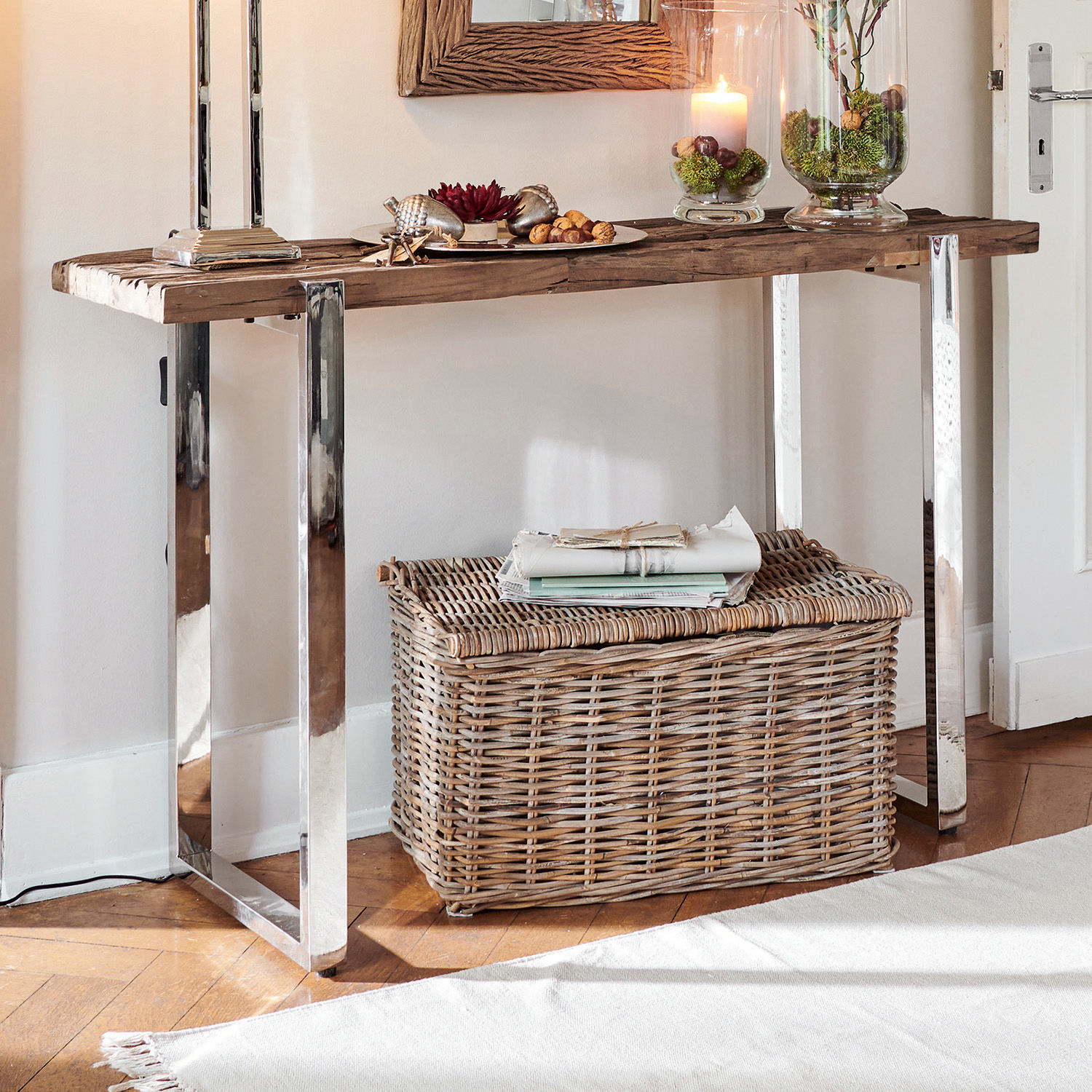 Consoletafel met houten blad en metalen poten, rieten mand op lichte vloer in kamer